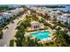 Aerial view showcases a community pool, colorful homes, and meticulous landscaping in a waterfront neighborhood at 311 Compass Point Dr # 101, Bradenton, FL 34209