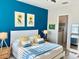 Bright bedroom with blue accent wall, a comfortable bed, and an ensuite bathroom at 311 Compass Point Dr # 101, Bradenton, FL 34209