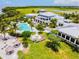 Aerial shot of a modern clubhouse featuring a large pool, jacuzzi, and lush tropical landscaping at 311 Compass Point Dr # 101, Bradenton, FL 34209