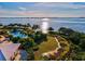 Scenic aerial view of a pool surrounded by palm trees, lush landscaping, and waterfront access at 311 Compass Point Dr # 101, Bradenton, FL 34209