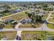 Aerial view of a white single-Gathering home with a dark roof, large yard, long driveway and in-ground pool at 3239 Daytona Dr, Punta Gorda, FL 33983