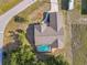 Birds-eye view of home with screened-in pool, surrounded by large grassy lot with mature trees at 3239 Daytona Dr, Punta Gorda, FL 33983