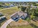 Aerial view of white single-Gathering home with a dark roof, large yard, long driveway and in-ground pool at 3239 Daytona Dr, Punta Gorda, FL 33983