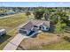 Aerial view of white single-Gathering home with a dark roof, large yard, long driveway and in-ground pool at 3239 Daytona Dr, Punta Gorda, FL 33983