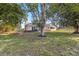 View of the rear of the house, a screened lanai, and large tree at 3239 Daytona Dr, Punta Gorda, FL 33983