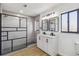 A bathroom with modern black framed shower, dual vanity with framed mirrors, and wood floors at 3239 Daytona Dr, Punta Gorda, FL 33983