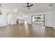 Spacious living area with light wood flooring, a modern ceiling fan, and open view to the kitchen and backyard pool at 3239 Daytona Dr, Punta Gorda, FL 33983