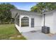 Enclosed porch and exterior of home featuring modern door, AC unit, and view of yard at 3303 32Nd W St, Bradenton, FL 34205