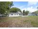 Backyard view with spacious grassy area, enclosed porch, and ample trees at 3303 32Nd W St, Bradenton, FL 34205