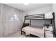 Cozy bedroom with a bunk bed, wood floors, and natural light from the sheer-curtained window at 3303 32Nd W St, Bradenton, FL 34205