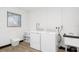 Bright laundry room with white appliances, wood look floors, a window and a utility sink at 3303 32Nd W St, Bradenton, FL 34205