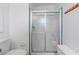 Bathroom featuring a glass enclosed shower, white tiled walls, and neutral tile flooring at 3352 Laurel Oak Way, Sarasota, FL 34237