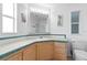 Bright bathroom with green tile, wood vanity and a large mirror at 3352 Laurel Oak Way, Sarasota, FL 34237