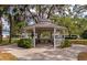 View of the community gazebo shaded by mature trees and featuring landscaped flower beds at 3352 Laurel Oak Way, Sarasota, FL 34237