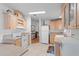 Well-lit kitchen with white appliances, light wood cabinetry, tile backsplash, and durable tile floors at 3352 Laurel Oak Way, Sarasota, FL 34237