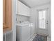 Bright laundry room with white washer and dryer, white cabinets and tiled floor at 3352 Laurel Oak Way, Sarasota, FL 34237