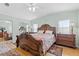 Spacious bedroom with unique wood bedframe, hardwood flooring, and ample natural light at 3352 Laurel Oak Way, Sarasota, FL 34237
