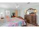 Bedroom featuring hardwood floors, ceiling fan and large bureau with vintage mirror at 3352 Laurel Oak Way, Sarasota, FL 34237