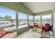 Bright sun room with vaulted ceiling, large windows and a small table and chairs at 3352 Laurel Oak Way, Sarasota, FL 34237