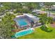 Aerial view of enclosed pool with an adjacent shuffleboard court and gathering spaces at 3750 Pinebrook Cir # 405, Bradenton, FL 34209