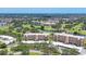Wide aerial shot showcases the condo buildings nestled amidst the golf course and mature trees at 3750 Pinebrook Cir # 405, Bradenton, FL 34209
