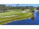 Picturesque golf course view featuring lush green, mature trees, sand traps, and a tranquil pond at 3750 Pinebrook Cir # 405, Bradenton, FL 34209