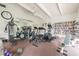 Bright gym area featuring exercise equipment, a wall of books, ceiling fan, and neutral color scheme at 3750 Pinebrook Cir # 405, Bradenton, FL 34209