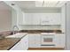 Clean kitchen with white cabinets, granite counters, and modern appliances at 3750 Pinebrook Cir # 405, Bradenton, FL 34209