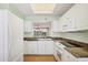 Updated kitchen with white cabinets, stone counters, and stainless steel appliances at 3750 Pinebrook Cir # 405, Bradenton, FL 34209