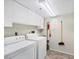 Well-lit laundry room equipped with a washer, dryer, and ample overhead cabinet storage at 3750 Pinebrook Cir # 405, Bradenton, FL 34209