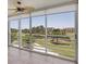 Bright living room featuring tile flooring, a ceiling fan, and sliding glass doors showcasing scenic golf course views at 3750 Pinebrook Cir # 405, Bradenton, FL 34209