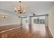 Spacious living room with hardwood floors, mirrored wall, chandelier, and sliding glass doors at 3750 Pinebrook Cir # 405, Bradenton, FL 34209