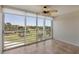 Bright living room featuring tile flooring, a ceiling fan, and sliding glass doors showcasing scenic golf course views at 3750 Pinebrook Cir # 405, Bradenton, FL 34209