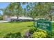 Community signage on manicured grounds welcomes visitors to The Woods at 3750 Pinebrook Circle at 3750 Pinebrook Cir # 405, Bradenton, FL 34209