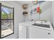 Well-equipped laundry room with modern washer and dryer and outdoor view at 4079 Woodview Dr, Sarasota, FL 34232