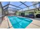 Beautiful screened-in swimming pool, with a rear view of the home and outdoor seating area at 4079 Woodview Dr, Sarasota, FL 34232