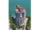 Stunning aerial view of a luxury beachfront condo building with a golden dome and panoramic water views at 420 Golden Gate Pt # 200A, Sarasota, FL 34236