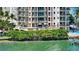 Balcony view of the waterfront highlights the lush landscaping below at 420 Golden Gate Pt # 200A, Sarasota, FL 34236