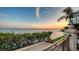 Picture of a balcony with lush greenery and a panoramic water view at sunset at 420 Golden Gate Pt # 200A, Sarasota, FL 34236