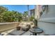 Covered balcony with comfortable patio furniture overlooking tropical landscaping and a building under construction at 420 Golden Gate Pt # 200A, Sarasota, FL 34236