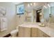 Bright bathroom features a large mirror, vanity, toilet, and a shower area visible through the mirror reflection at 420 Golden Gate Pt # 200A, Sarasota, FL 34236