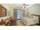 Bright bedroom featuring tropical-themed decor, a ceiling fan, hardwood floors, and an exterior patio at 420 Golden Gate Pt # 200A, Sarasota, FL 34236
