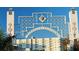 Sarasota Bayfront entrance features a decorative archway with a shell motif and a view of the waterfront buildings at 420 Golden Gate Pt # 200A, Sarasota, FL 34236