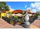 Cozy outdoor dining area with unique tiki umbrellas, surrounded by lush greenery and a statue at 420 Golden Gate Pt # 200A, Sarasota, FL 34236