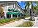 A building featuring awnings, greenery, and palm trees along the sidewalk at 420 Golden Gate Pt # 200A, Sarasota, FL 34236
