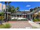Charming building featuring distinctive Tudor architecture, lush landscaping, and a red door entrance at 420 Golden Gate Pt # 200A, Sarasota, FL 34236