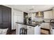 Contemporary kitchen featuring white cabinets, a dark island, and stainless-steel appliances, great for cooking and socializing at 420 Golden Gate Pt # 200A, Sarasota, FL 34236