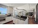 Modern kitchen with white cabinetry, black countertops, island, and water view at 420 Golden Gate Pt # 200A, Sarasota, FL 34236