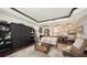 Open-concept condo living room flows into the dining area, featuring wood floors and custom cabinetry at 420 Golden Gate Pt # 200A, Sarasota, FL 34236