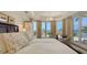 Bright main bedroom with large windows offering panoramic water views from the bed at 420 Golden Gate Pt # 200A, Sarasota, FL 34236